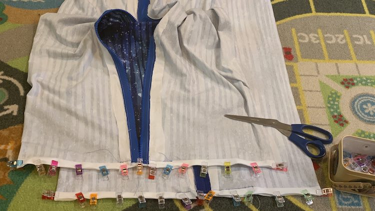 View of one end of both pillows. They're stacked slightly askew so you can see that end of both pillows at the same time. The ends of the zippers have been trimmed so you can see the fabric at the bottom.