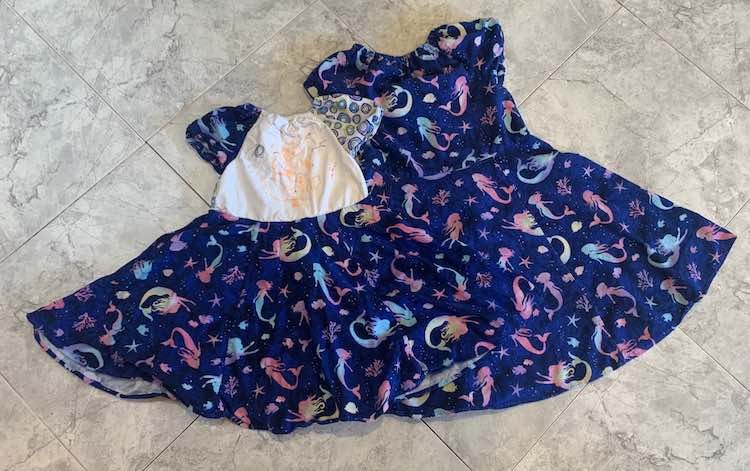 Flat lay of the two dresses on the kitchen floor.