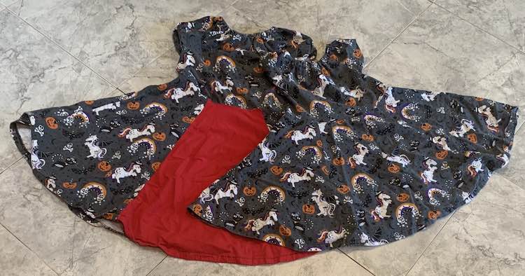 Flat lay of the two Halloween dresses on the kitchen floor.