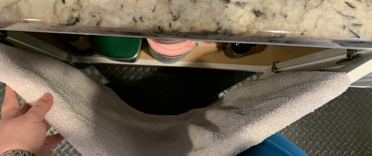 Image is taken from above while the white towel is pulled taunt and the doors are partially closing. My left hand keeps the towel in place and pulling while my legs push the doors closed.