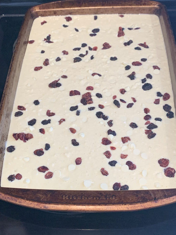 Image shows uncooked batter with red, black, and white dots in it. 