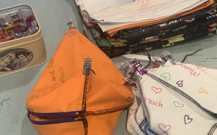 Image shows a pile of clipped and prepped box corner bags with a pile of other bags in the background.