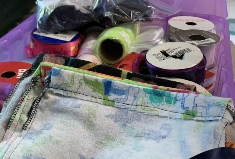 Image shows a stack of inside out baggies with rolls of ribbon in the background.