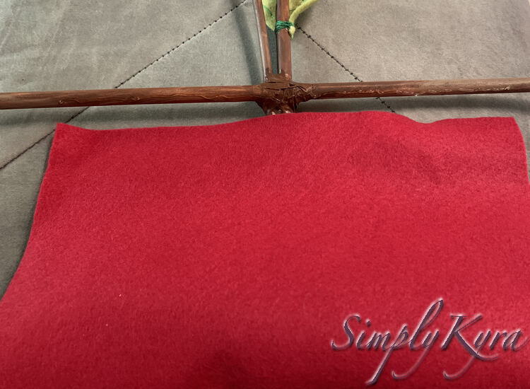 Image shows the felt folded towards the top horizontal mast. If you look closely at the horizontal mast you can see the clear glue squiggled on. The mast appears lower than before you can see the base of the leaf.