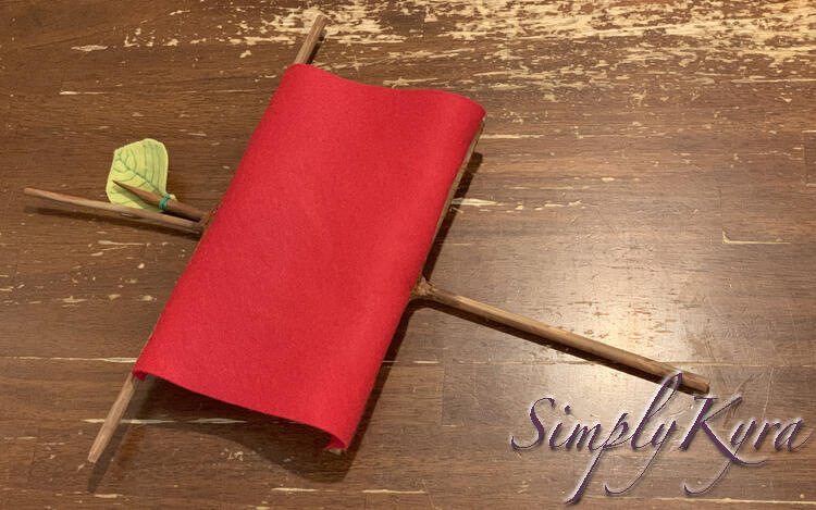 Image shows the mast and sail laid on it's side on the kitchen table. The sail is on top of the mast and although the ends are ballooned out the center sags in because of gravity.