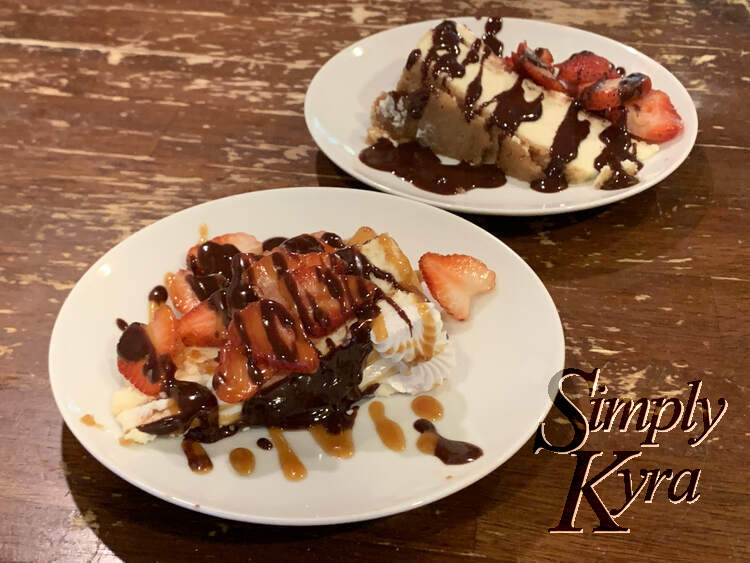 Image shows two plates with one in front of the other. Both have strawberries and chocolate sauce while the one in front also has caramel drizzled over it.