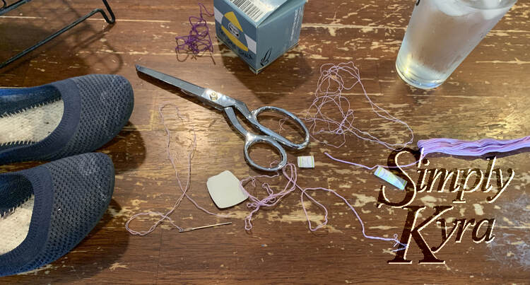 Image shows the chalk marked flats on the right, the embroidery floss on the right, and the threads in the center with the chalk and scissors laid out. Right beside the flats you can see the needle with a double set of threads extending from it and ending at a knot.