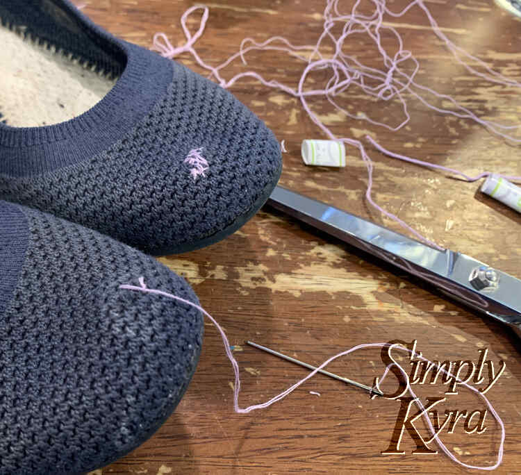 Image is a closeup of the tip of the flats showing the lavender patch in the back and the thread extending from the front flat. In the background you can see the rest of the threads, mu scissors, and the paper that had held the floss together.