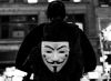 Man wearing a "Guy Fawkes" (from "V for Vendetta novel)  mask on his back.