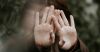 Photo of person covering shielding their eyes with their hands