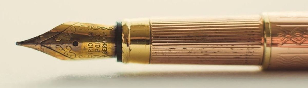 A brass fountain pen with a gold tip resting gently, evoking the start of a new story waiting to be told.