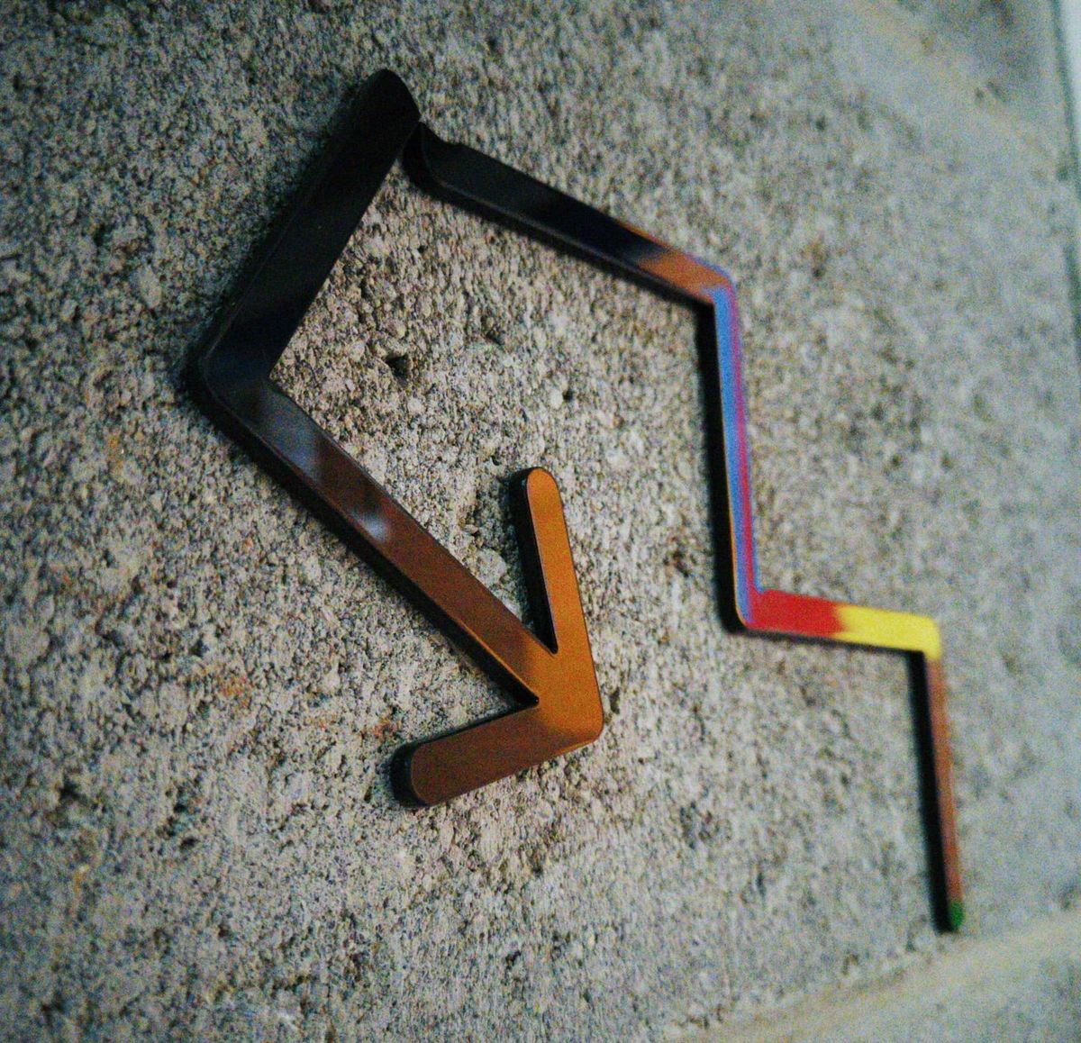 Graffiti metal arrow with zigzag design, pointing sideways to symbolize synchrodestiny, unexpected paths, and hidden synchronicity.