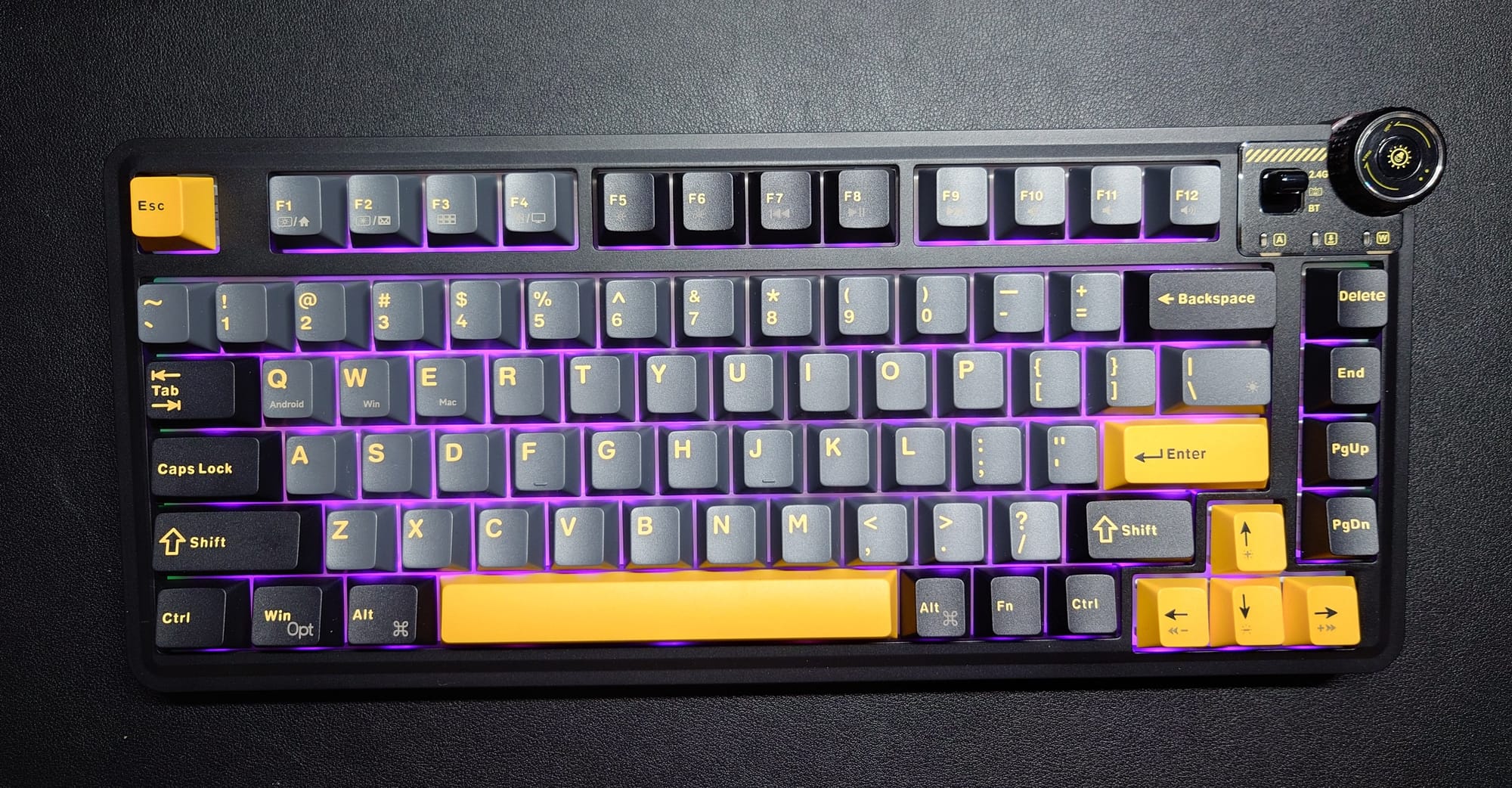 The Aula Design AU75 has dark gray and black keycaps with light orange lettering.  There is extra spacing to set off the Delete, End, PgUp, and PgDn buttons.  There is a black dial at the top right along with the switch to change from BT, wired, and wireless.