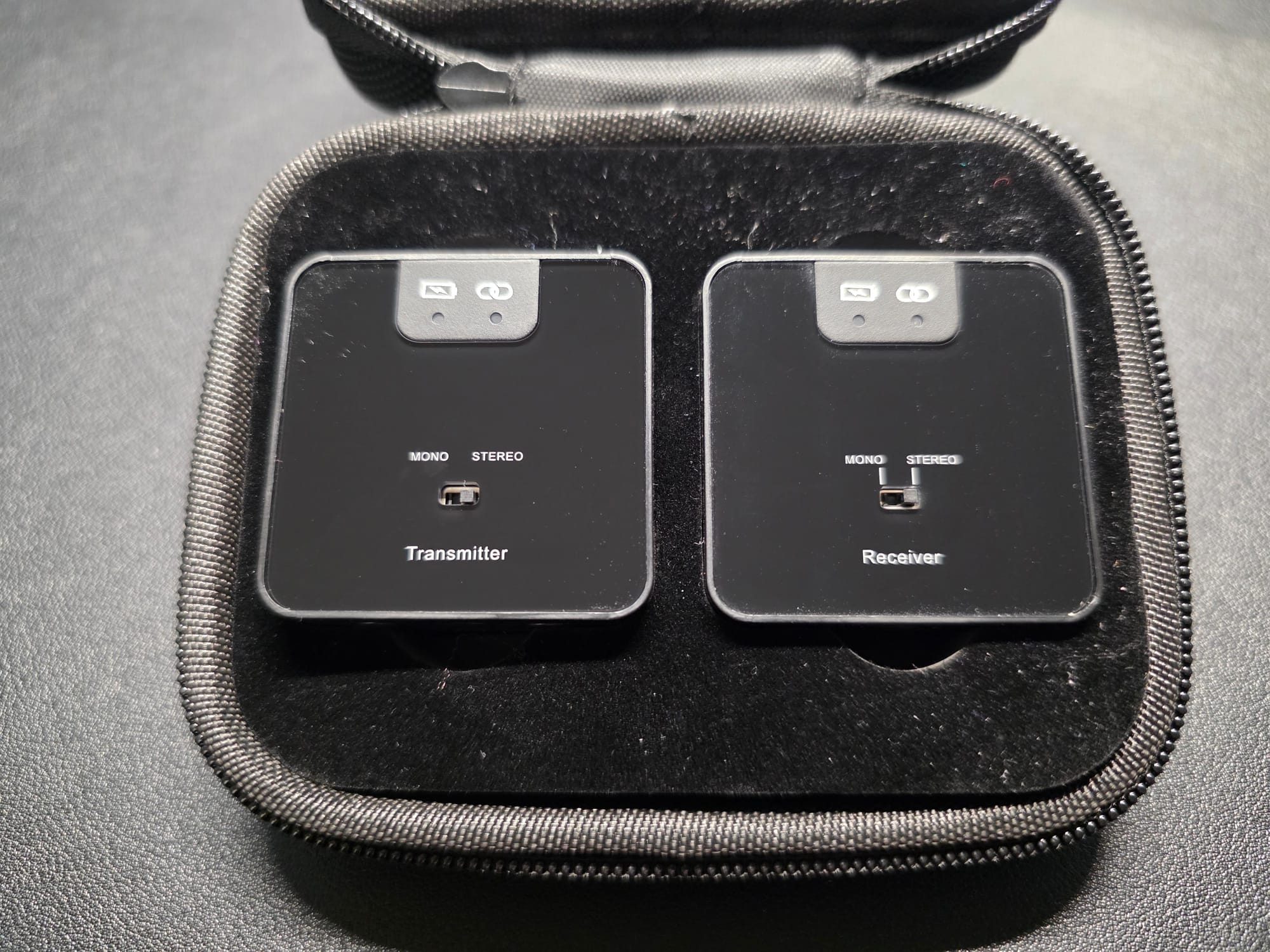 The Accessport Pro transmitter and receiver in their included case.  The case is black and is open displaying the devices next to each other.