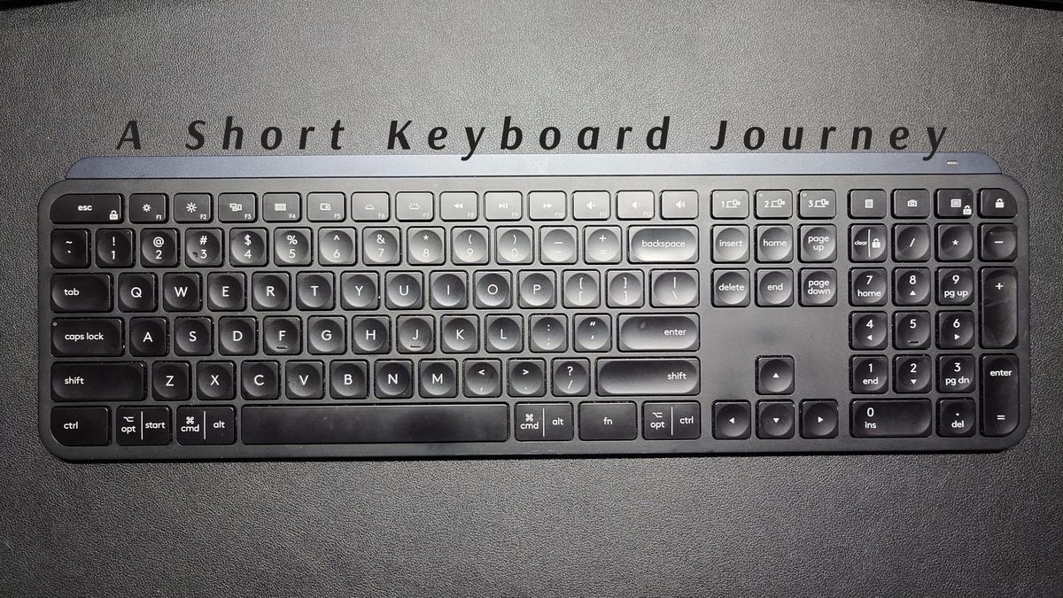 My previously loved Logitech MX Keys, a full-sized keyboard with number pad and typical low-profile keys with short travel