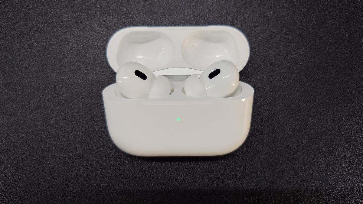 AirPods Pro 2 in their charging case, which is open, and the green light indicates high battery level