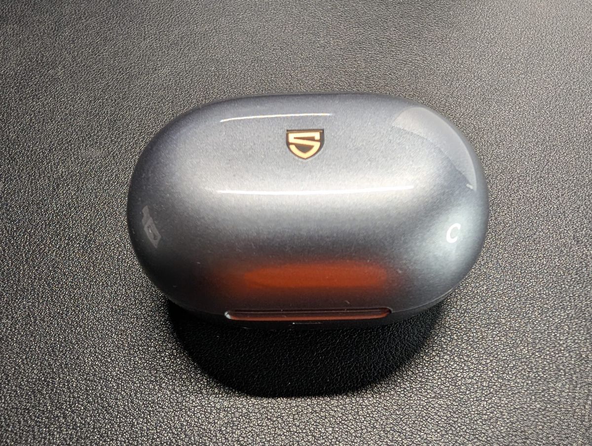 The SoundPeats Clip 1 closed in their shiny gray case with the stylized S logo on the top