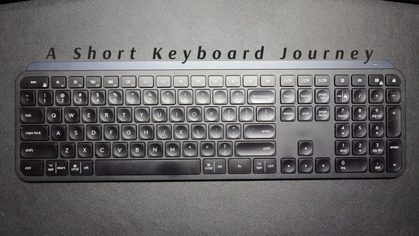 My previously loved Logitech MX Keys, a full-sized keyboard with number pad and typical low-profile keys with short travel