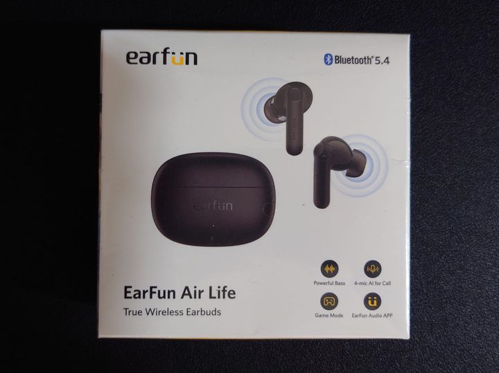 Photo of the box the earbuds come in, listing features such as 4 mics for calls, powerful bass, and audio app