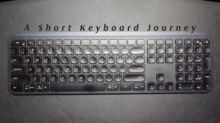 My previously loved Logitech MX Keys, a full-sized keyboard with number pad and typical low-profile keys with short travel