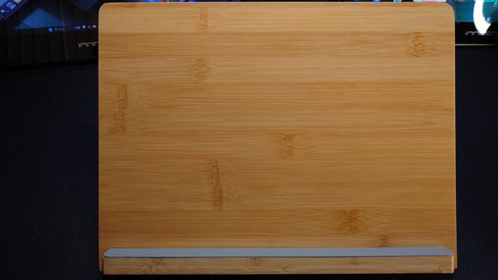 Photo of a wooden tablet stand with a gray rubber base for the tablet to sit on