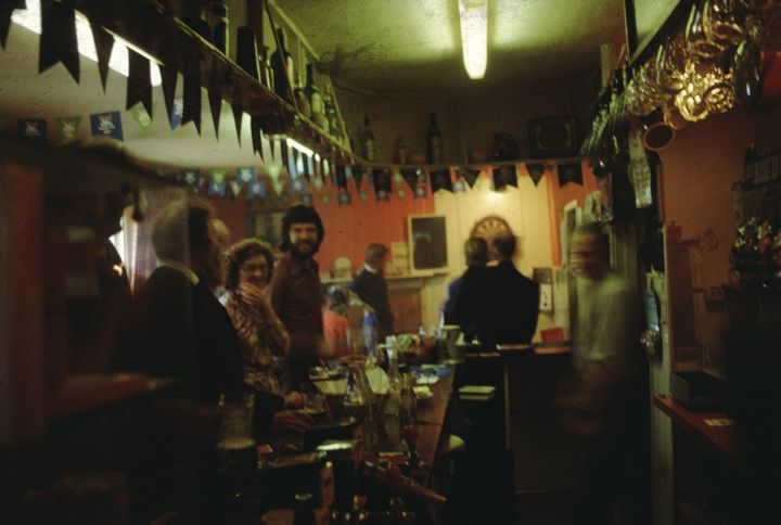 blurry color photo of patrons at a bar https://archive.org/details/GadoImages67372