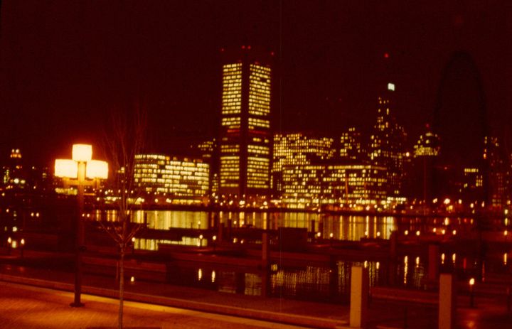 An image of the Baltimore harbor at night, tinted red and orange