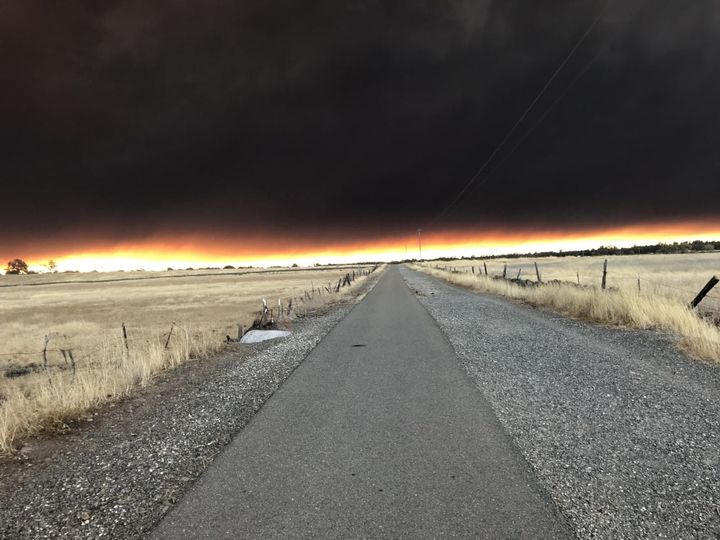 Photo of an asphalt road leading to a wall of smoke bordered by a bright white and orange stripe