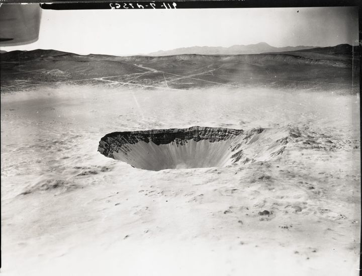 deep crater in a desert landscape, black and white