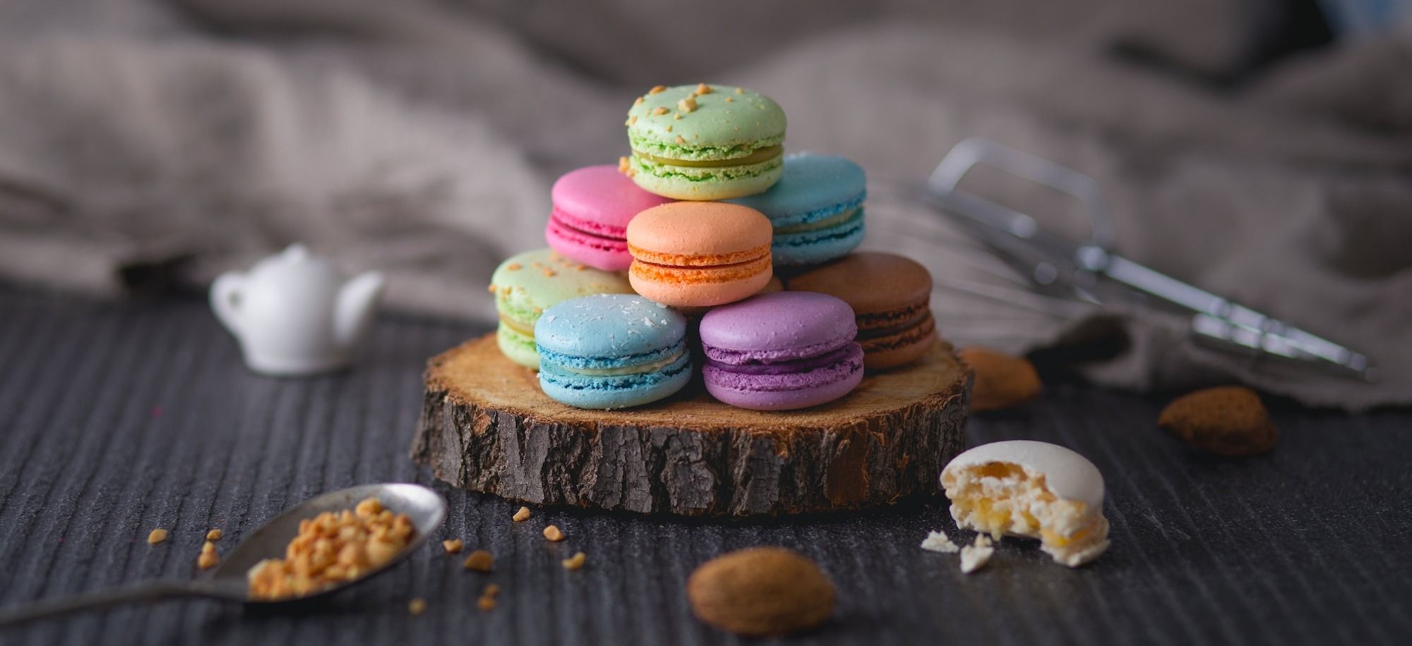 assorted-color macaroons on wood slab
