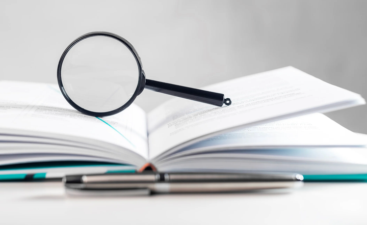 Magnifying glass on top of open books.
