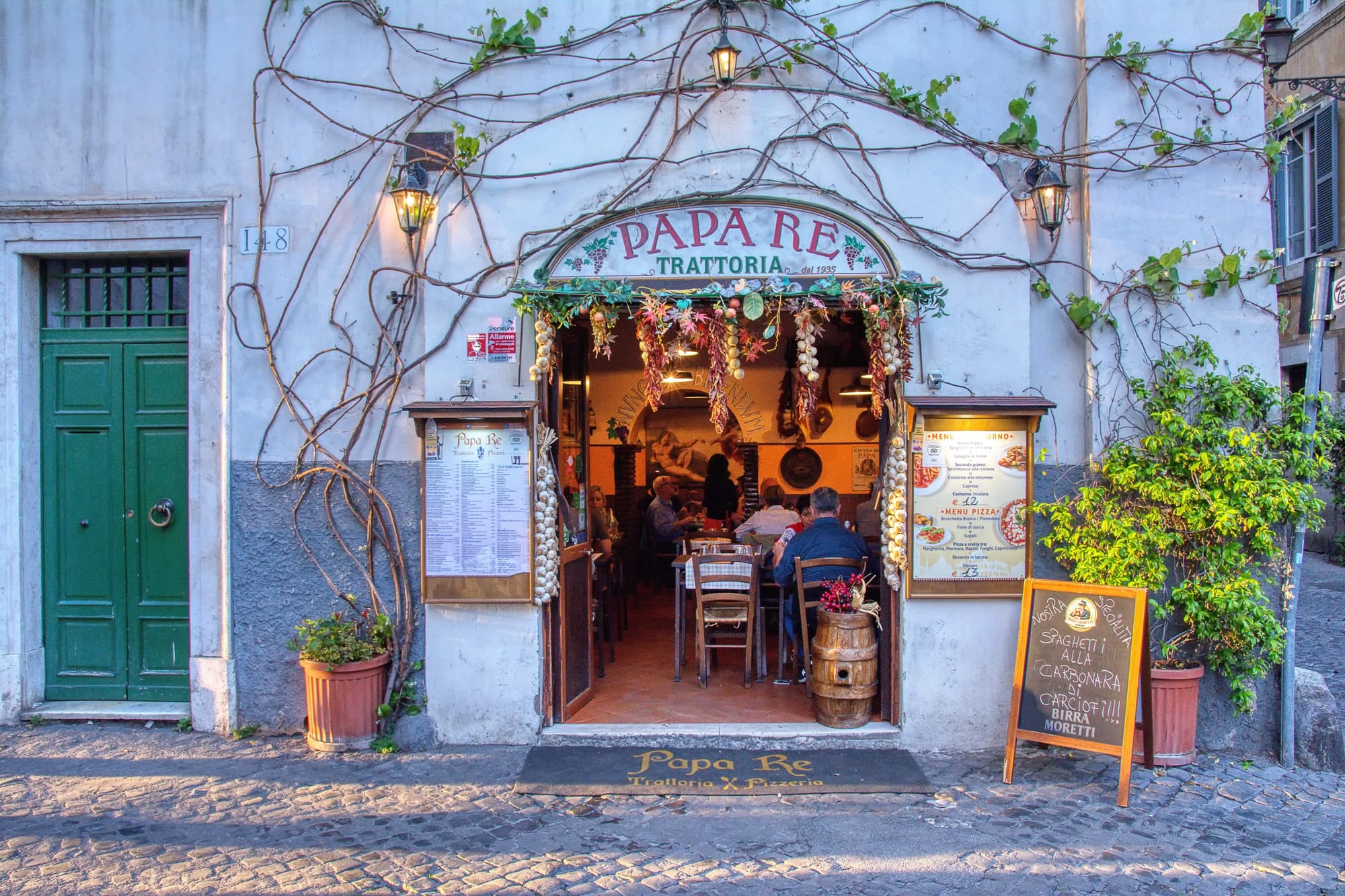 The historic facade of the trattoria Da Vittorio a Papa Re in the Trastevere neighborhood of Rome, famous for its authentic Roman cuisine.