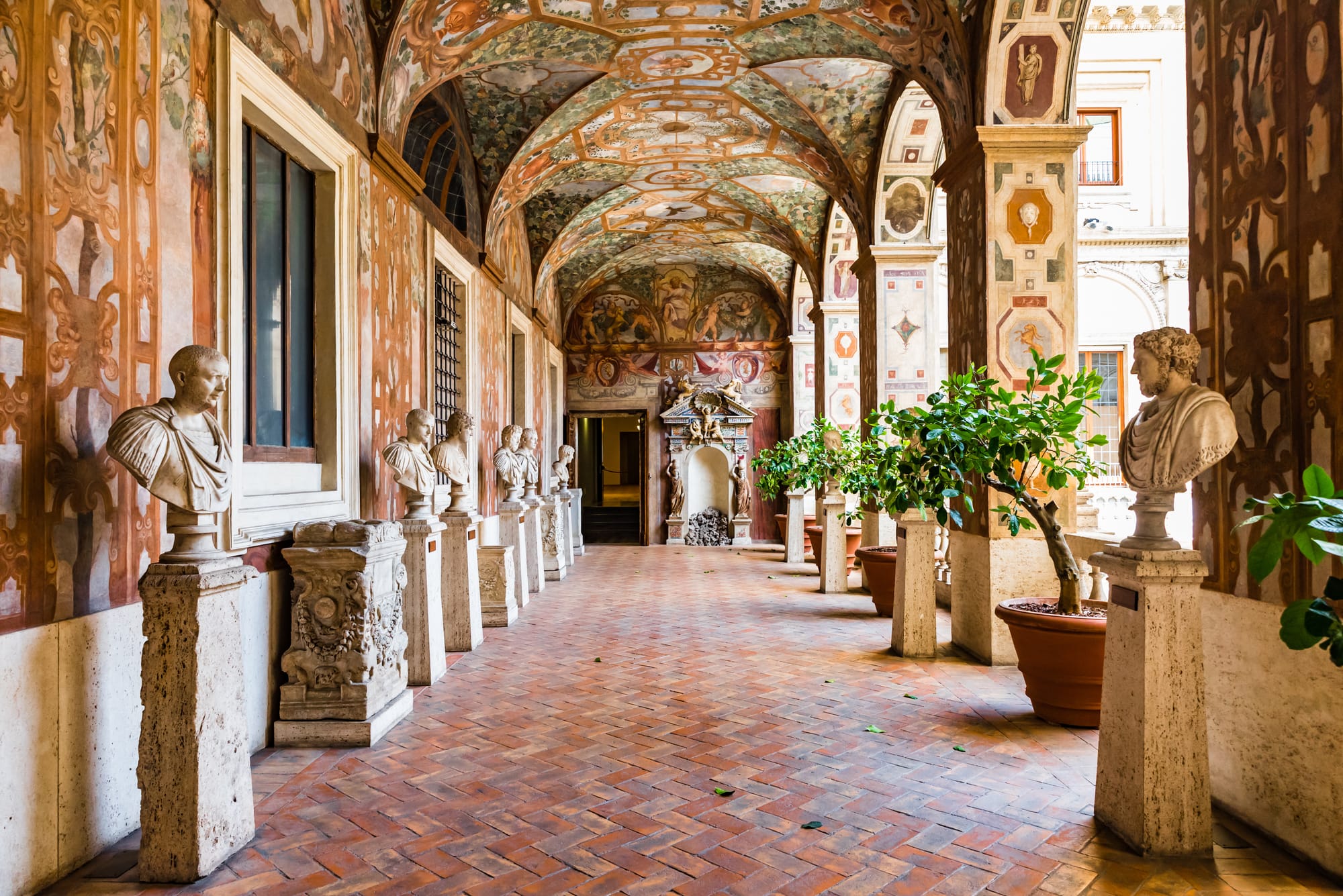 The colonnade of the Museo Nazionale Romano in Rome, with a row of ancient marble busts representing Roman art and history.