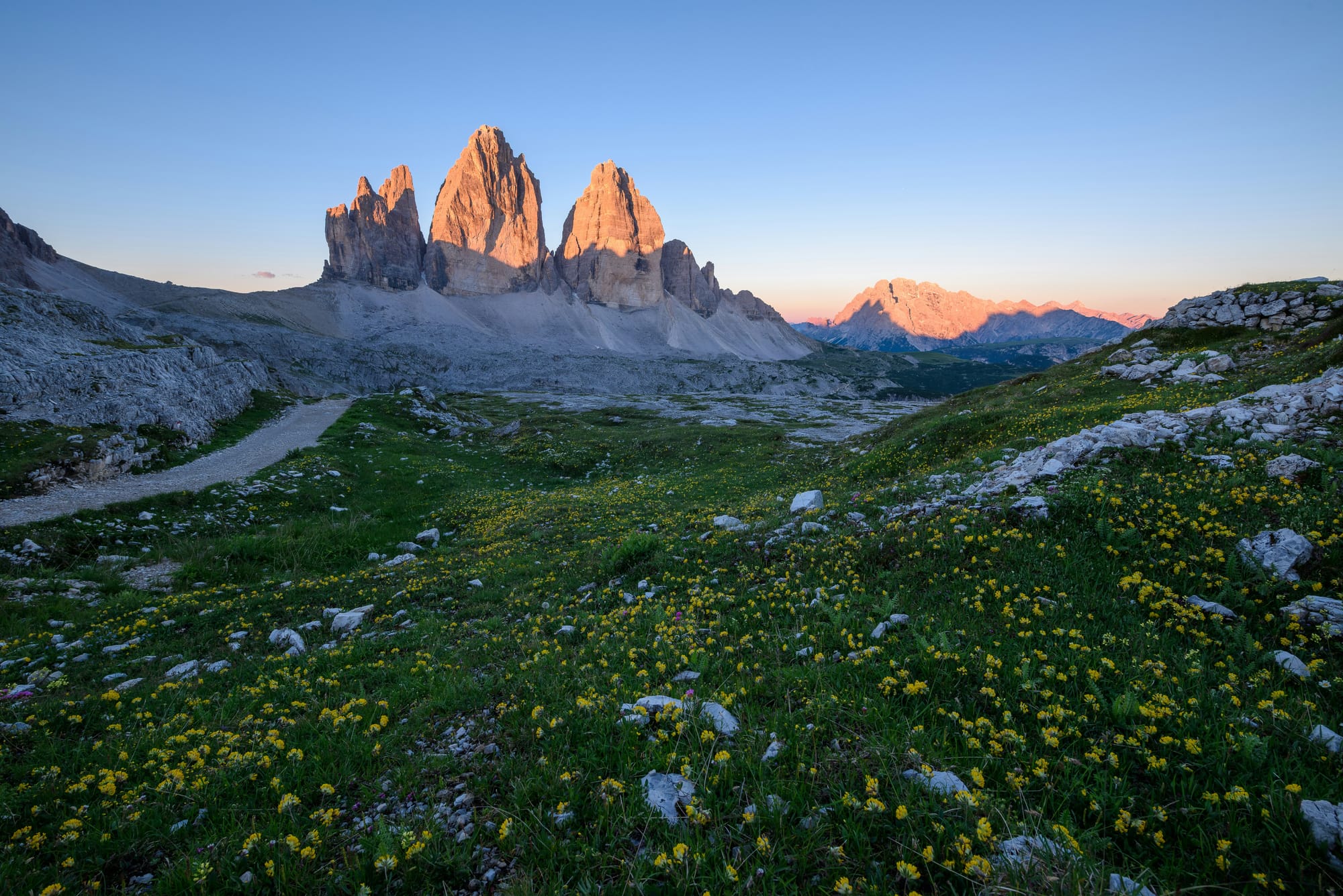 The iconic three peaks of Tre Cime di Lavaredo on a clear day, a popular hiking destination in the Italian Dolomites.