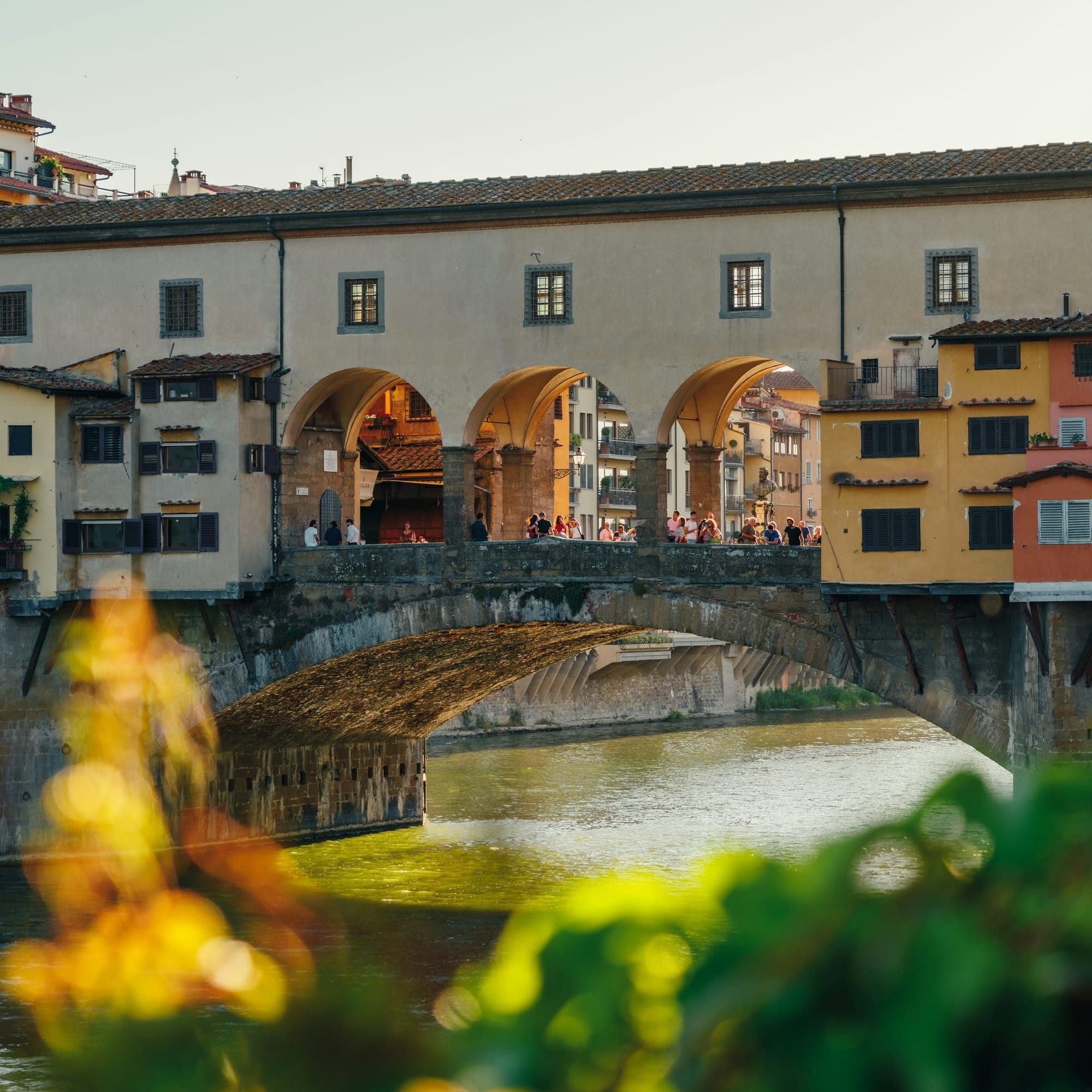 The historic Ponte Vecchio bridge over the Arno River in Florence, lined with jewelry shops.
