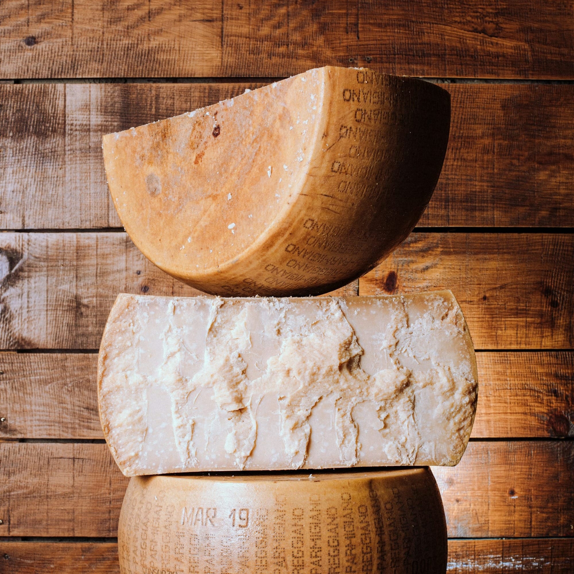 A large wheel of authentic Parmigiano Reggiano DOP cheese from Emilia-Romagna.