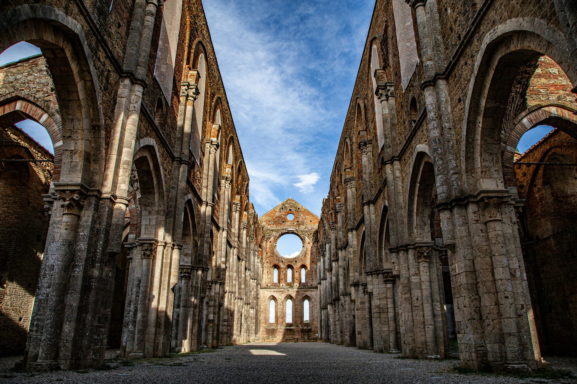 The roofless Gothic arches of the Abbey of San Galgano in the Tuscan countryside near Siena.