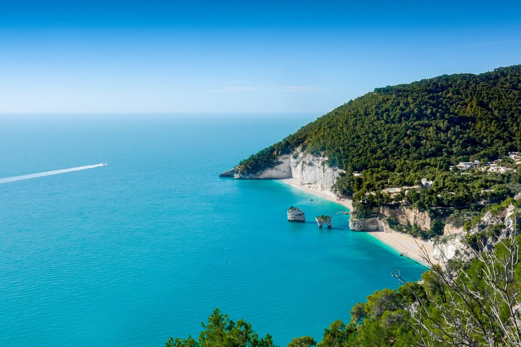 Aerial view of Baia delle Zagare beach in Gargano, Puglia, highlighting the famous white sea stacks, limestone cliffs, and the turquoise Adriatic Sea. One of the best beaches in Puglia.