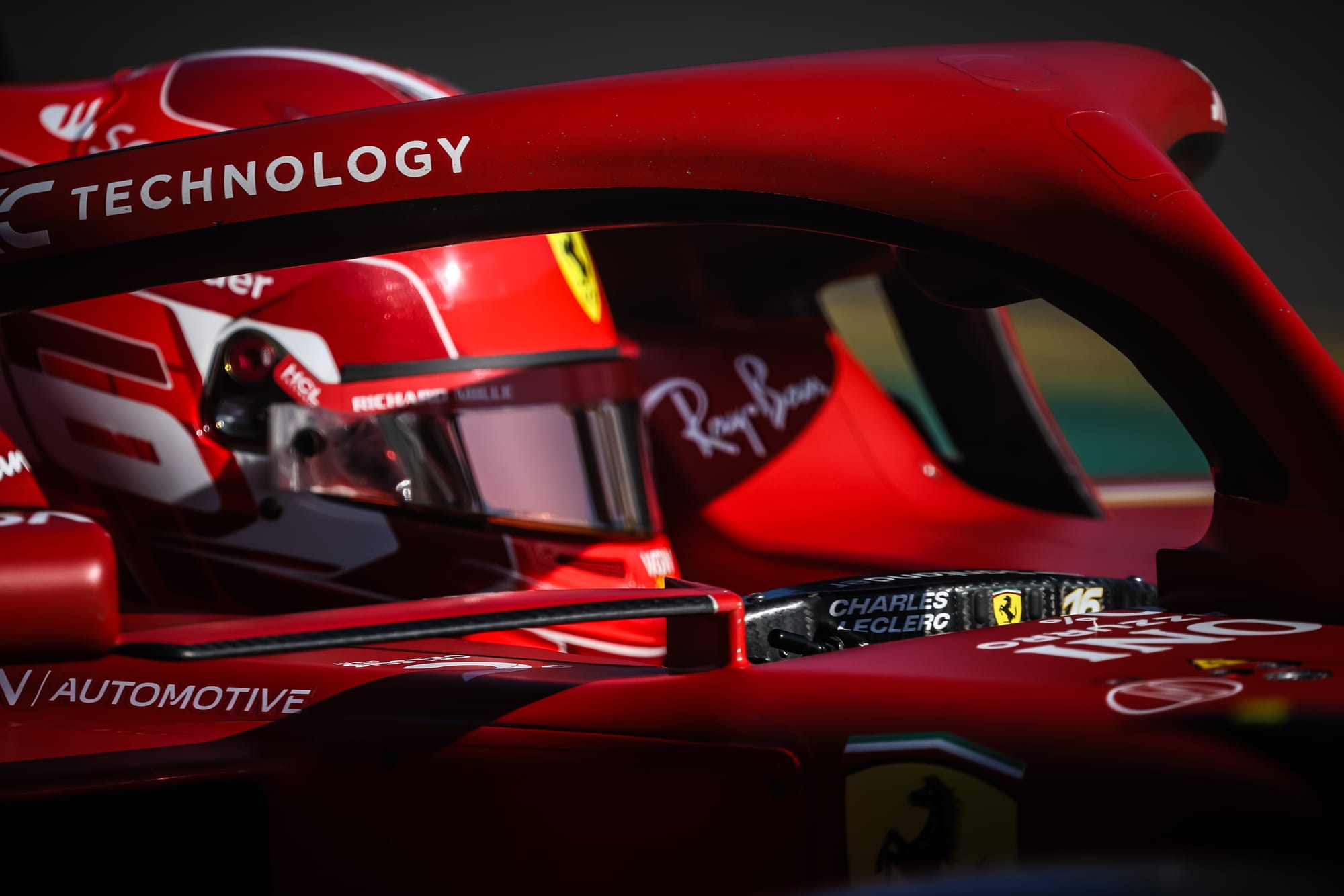 A detailed shot of Scuderia Ferrari driver Charles Leclerc's helmet, seen from behind the halo inside the cockpit of his F1 car.