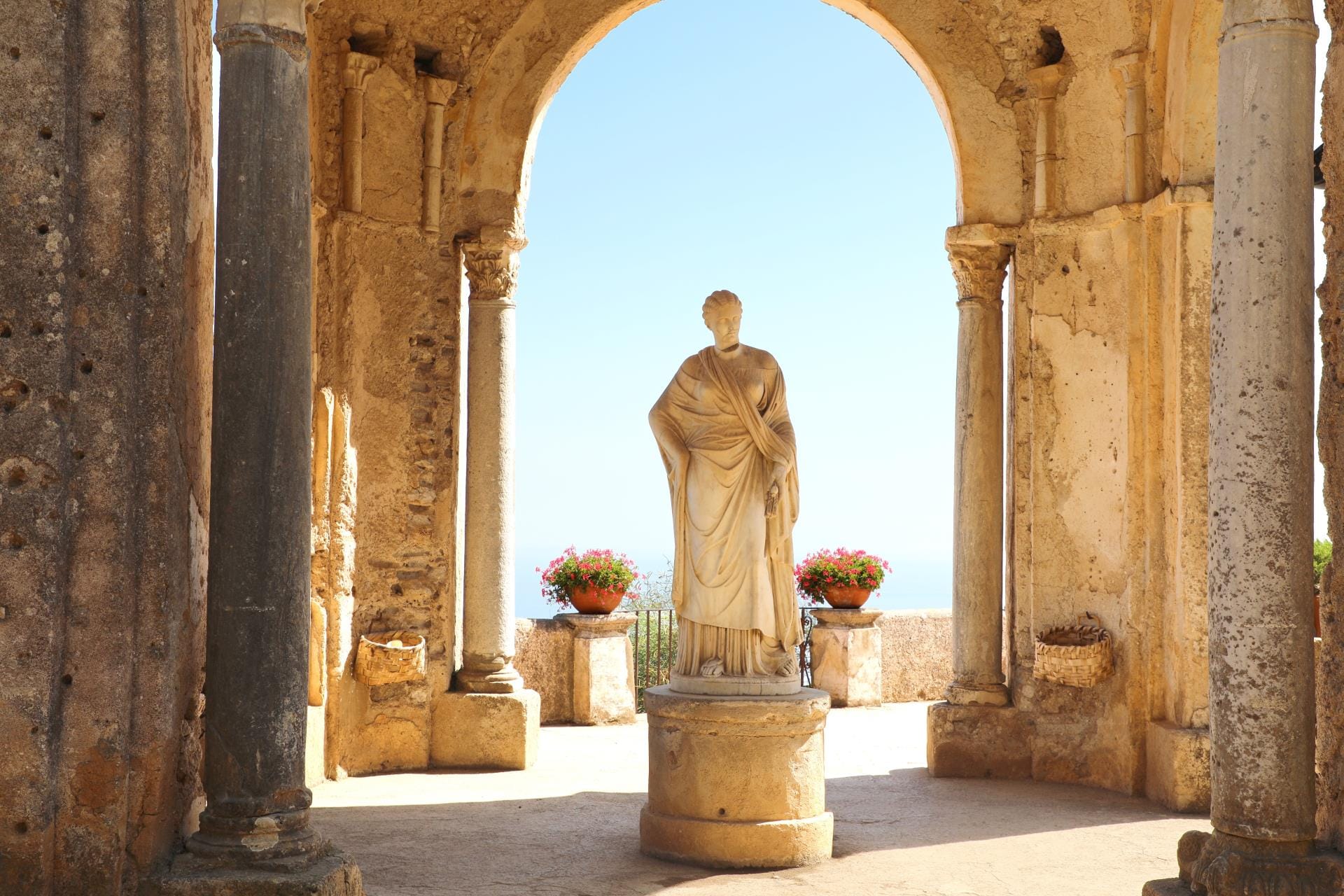 A classical marble statue in the historic gardens of Villa Cimbrone overlooking the sea in Ravello, Italy.