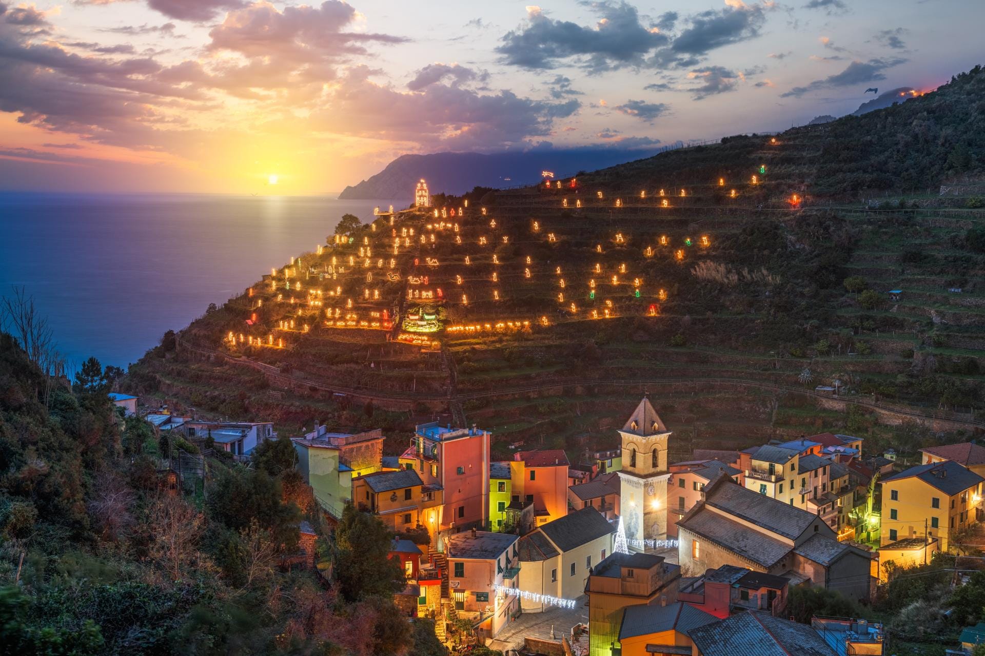 Manarola in Cinque Terre illuminated at night with the world's largest nativity scene during the Italian winter holidays.