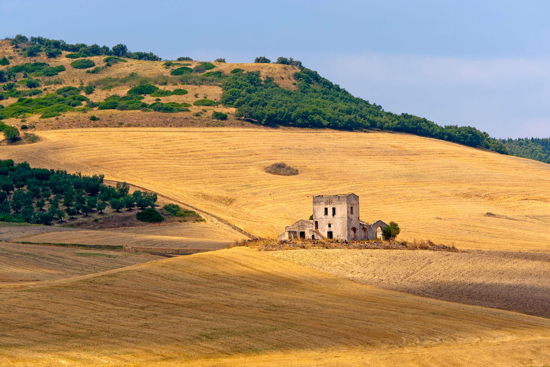 Rural landscape of Basilicata with ancient stone ruins and golden wheat fields, Southern Italy