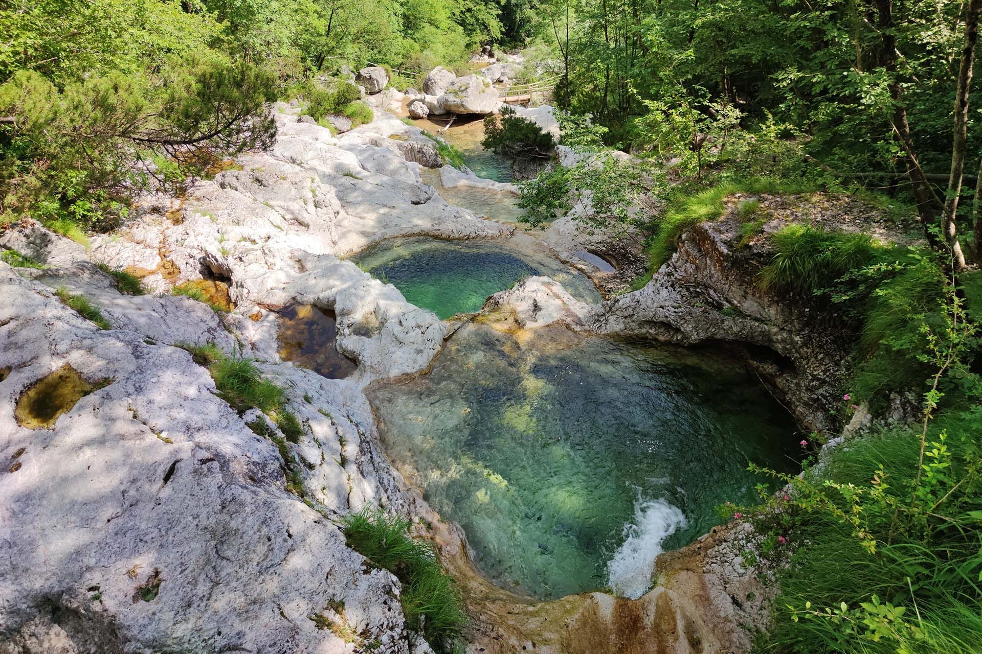 Emerald erosion pools of Cadini del Brenton carved in pale limestone, Dolomiti Bellunesi National Park, Belluno, Veneto, Italy.