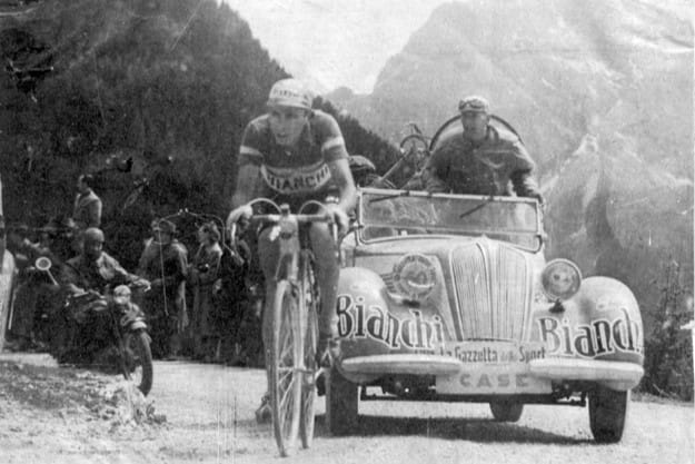 Fausto Coppi climbing solo in the 1949 Giro d'Italia in Bianchi jersey, Dolomites, team car behind