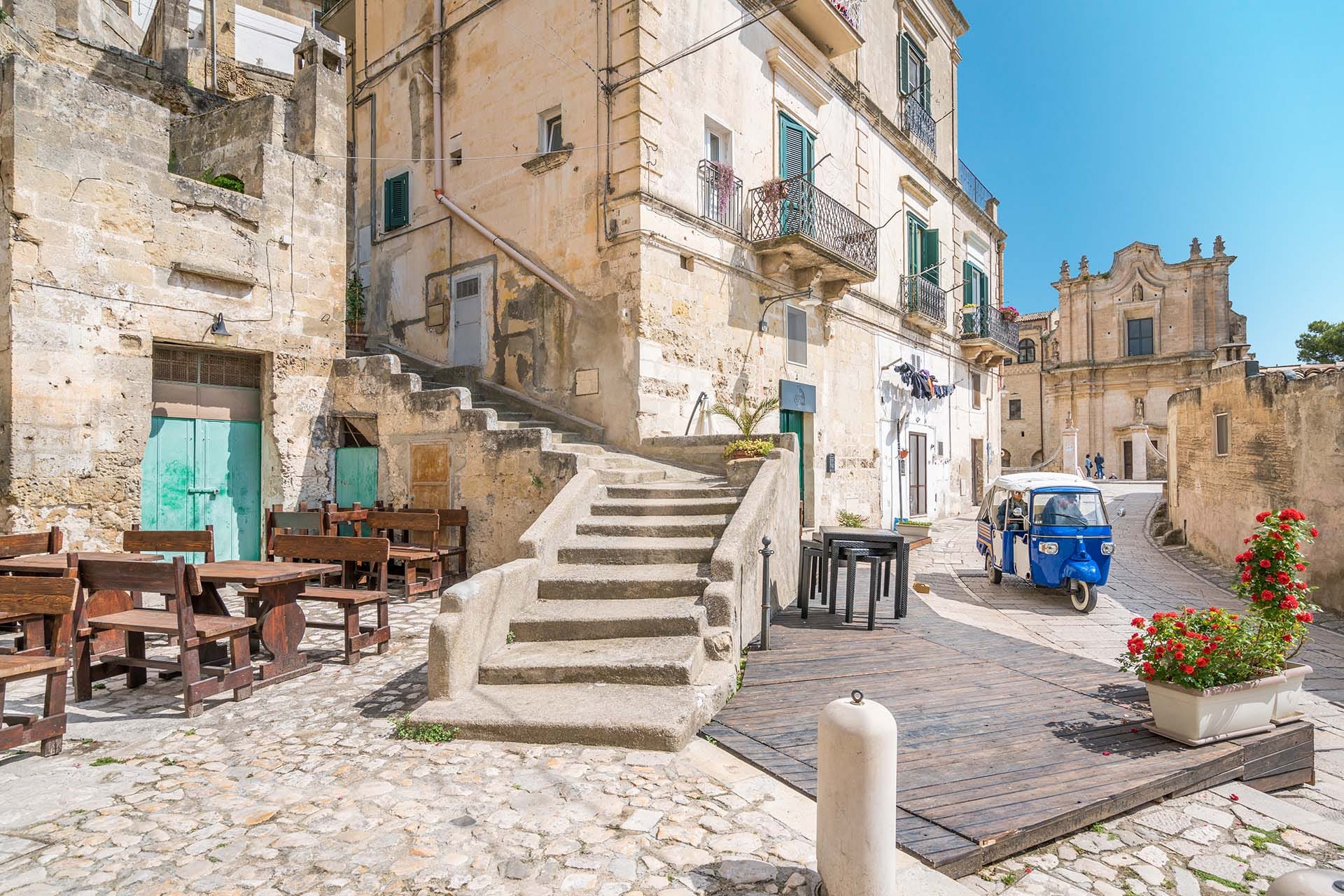 A blue Ape Car on the ancient stone streets of Matera, Basilicata, UNESCO World Heritage Site