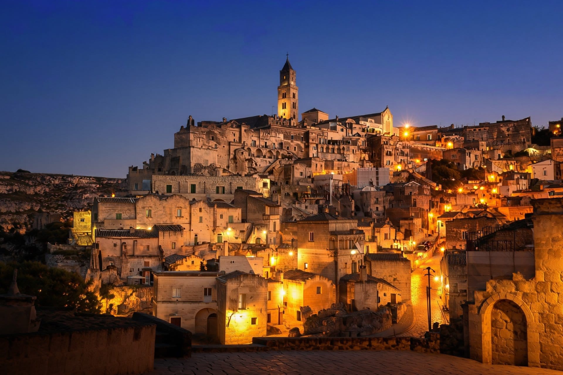 The ancient cave city of Matera (Sassi di Matera) glowing with warm golden light at dusk, UNESCO World Heritage Site, Basilicata, southern Italy