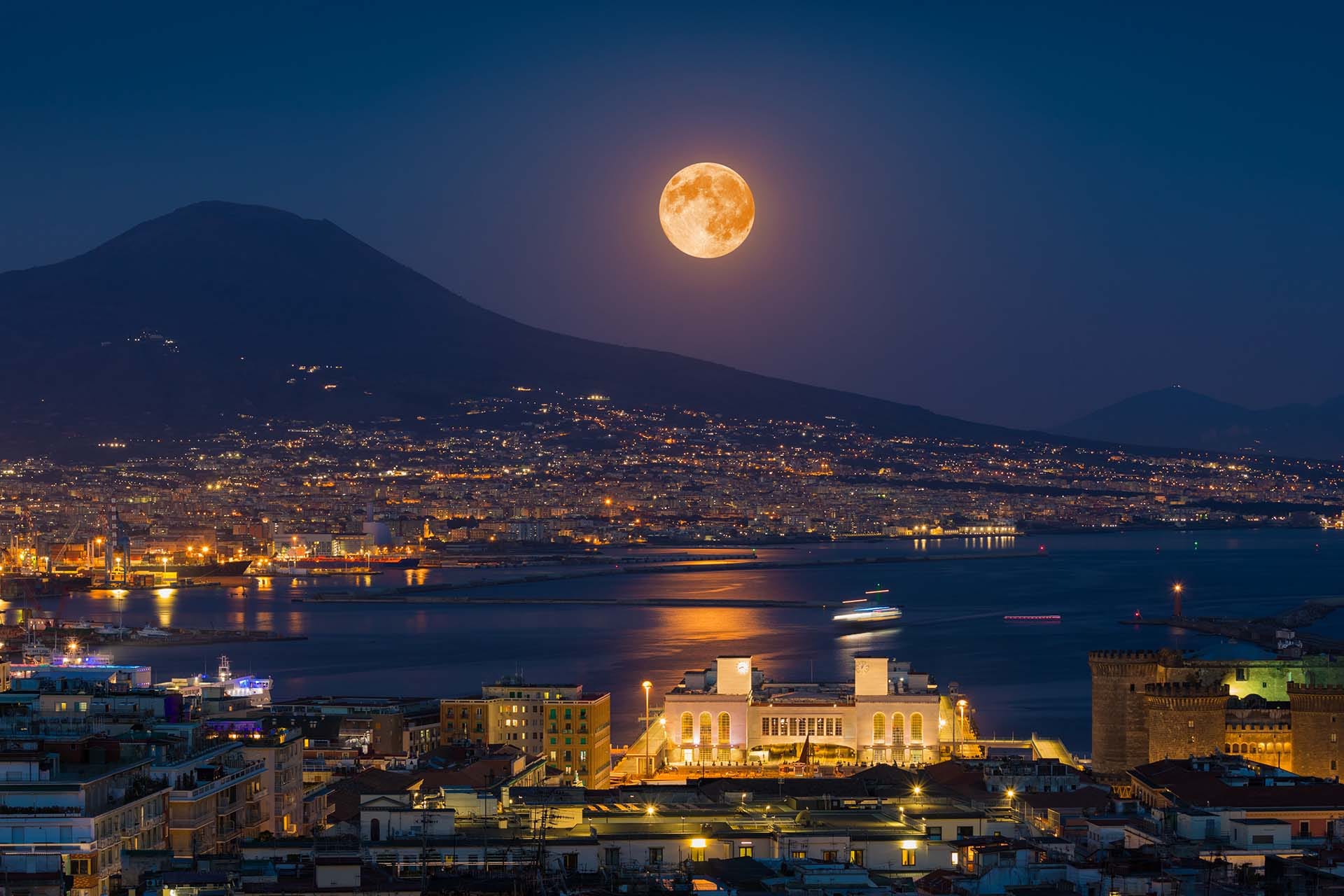 Full moon rising above Mount Vesuvius and the Bay of Naples at night, Campania, Southern Italy