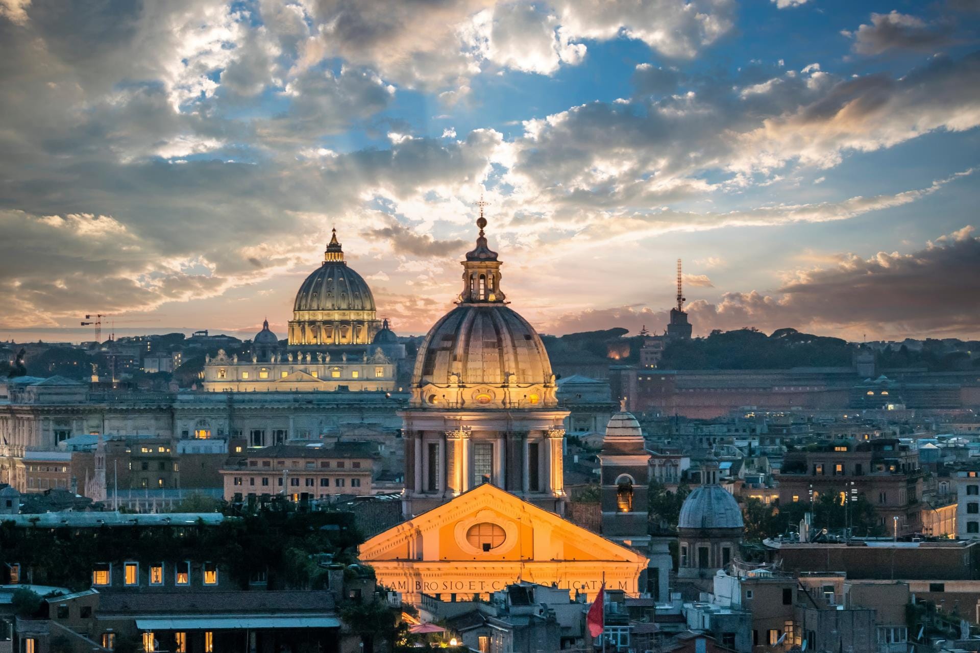 Breathtaking sunset casting a warm golden glow over the historical skyline of Rome, with the iconic dome of St. Peter's Basilica in Vatican City standing out in the distance.