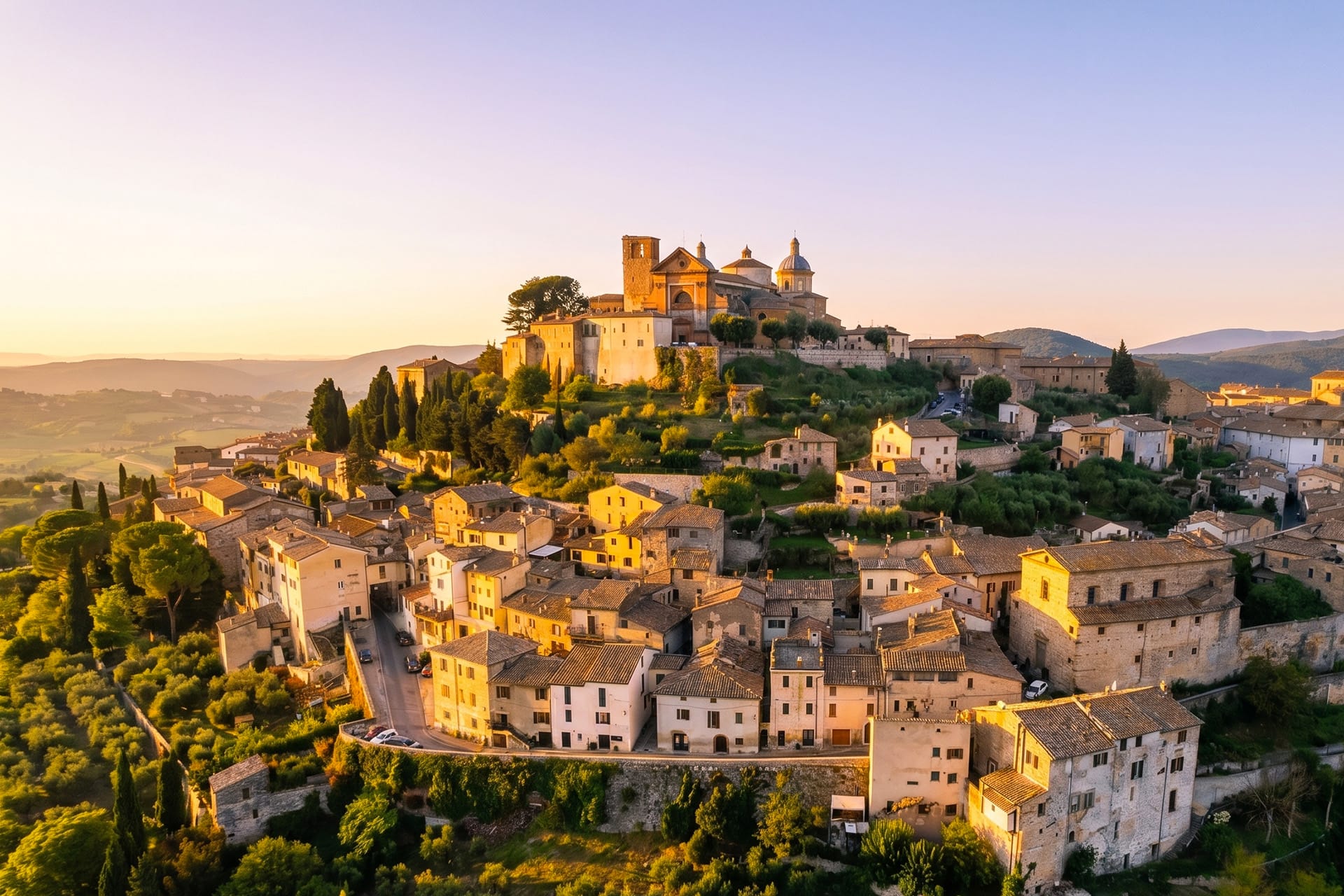 Golden hour over the hill town of Amelia in Umbria, stone houses rising to the hilltop cathedral