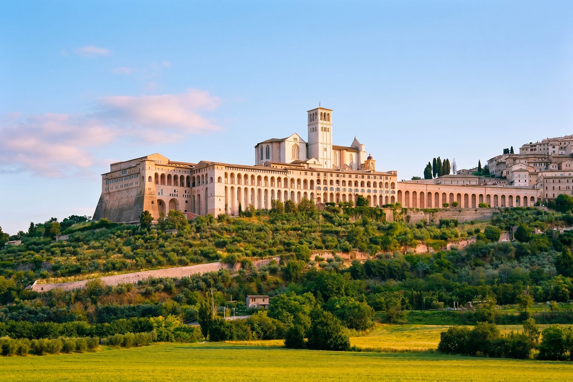 Basilica di San Francesco on its hilltop above Assisi at golden hour in autumn